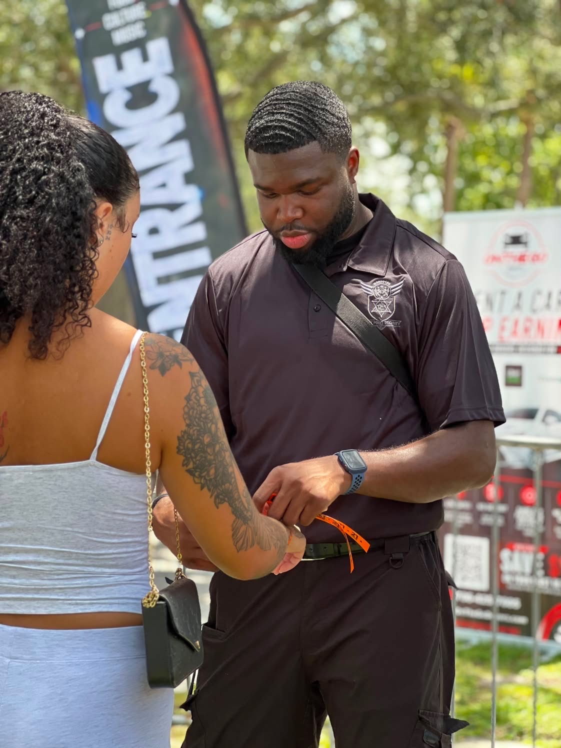 Trust Point Security officer applying an entry wristband to a guest at the event gate
